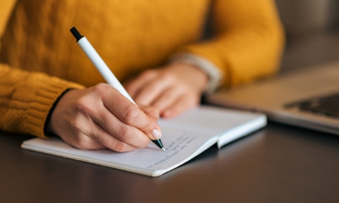 Writing in notebook. Close-up.