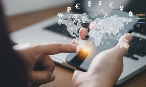 Curso de Relaciones Internacionales Man using mobile phone and laptop computer to money transfers and currency exchanges between countries of the world. online banking interbank payment concept.