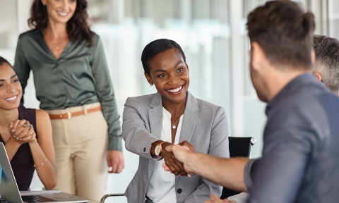 Mature black businesswoman shaking hands with new business partner