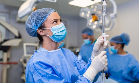 Female Doctor in the operating room putting drugs through an IV - surgery concepts