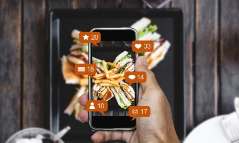 Taking food photograph by mobile smart phone, and sharing on social media, social network with notification icons