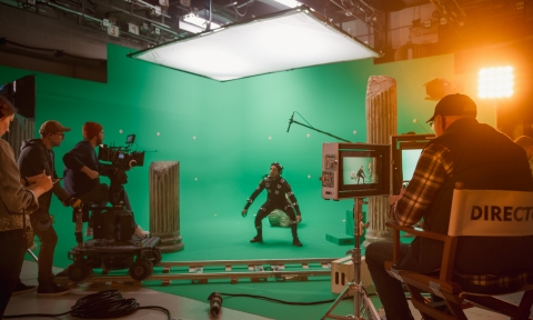 Curso de Televisión In the Big Film Studio Professional Crew Shooting Blockbuster Movie. Director Commands Cameraman to Start shooting Green Screen CGI Scene with Actor Wearing Motion Capture Suit and Head Rig