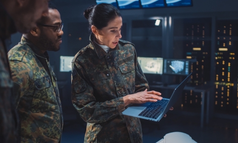International Team of Military Personnel Have Meeting in Top Secret Facility, Female Leader Holds Laptop Computer Talks with Male Specialist. People in Uniform on Strategic Army Meeting