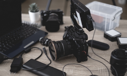 Curso de Tipos de Fotografía top view of work space photographer with digital camera, flash, cleaning kit, memory card, tripod and camera accessory on black table background