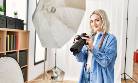 Curso de Fotografía digital Beautiful blonde woman working as professional photographer at photography studio. Standing holding camera smiling confident.