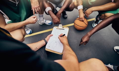 Basketball, strategy and team with a sports coach talking to a team while planning tactics on a clipboard and hands. Teamwork, fitness and exercise with a player and teammates listening at training